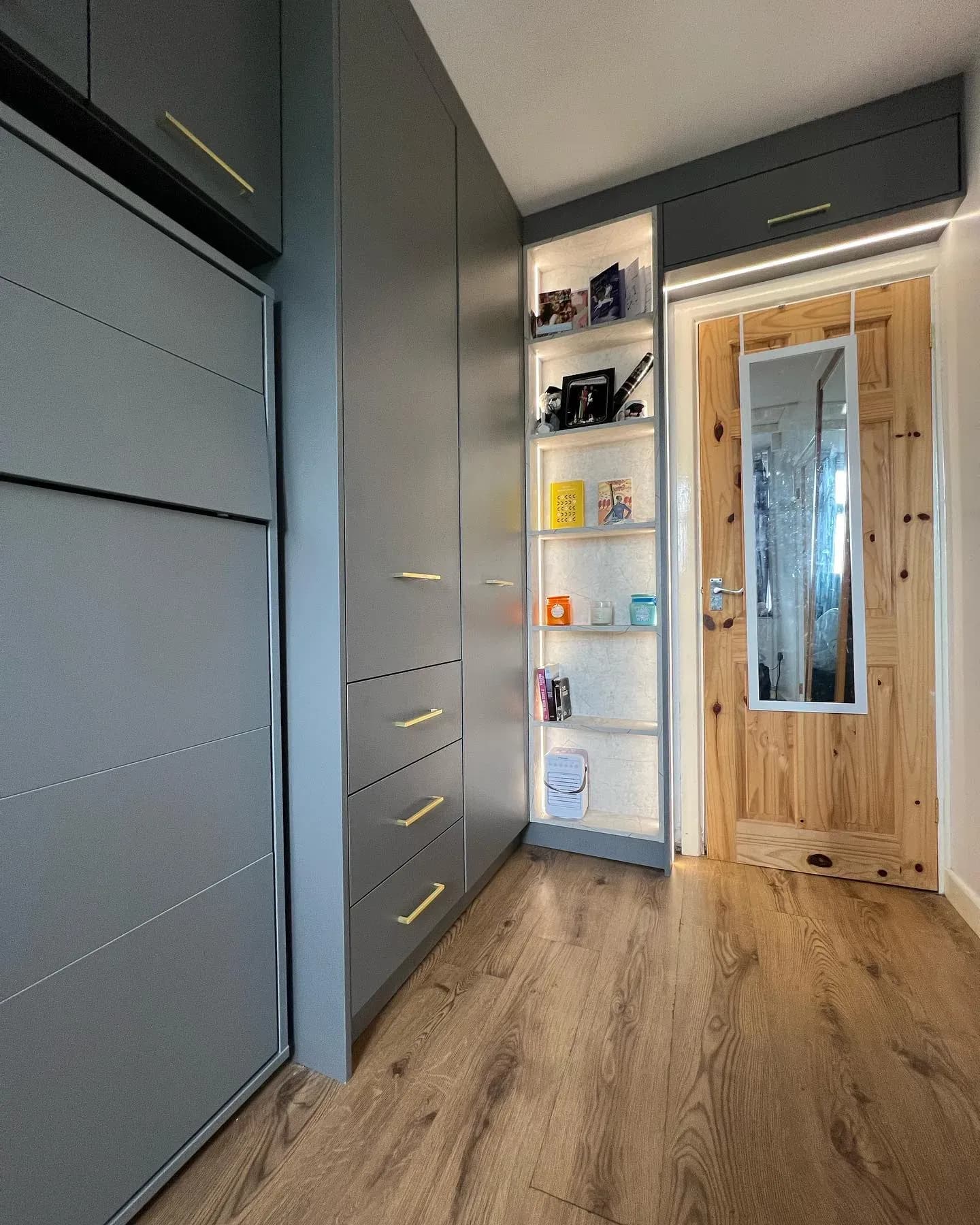 Matt grey fitted wardrobes with lit marble-backed display niches and oak floor, real installation