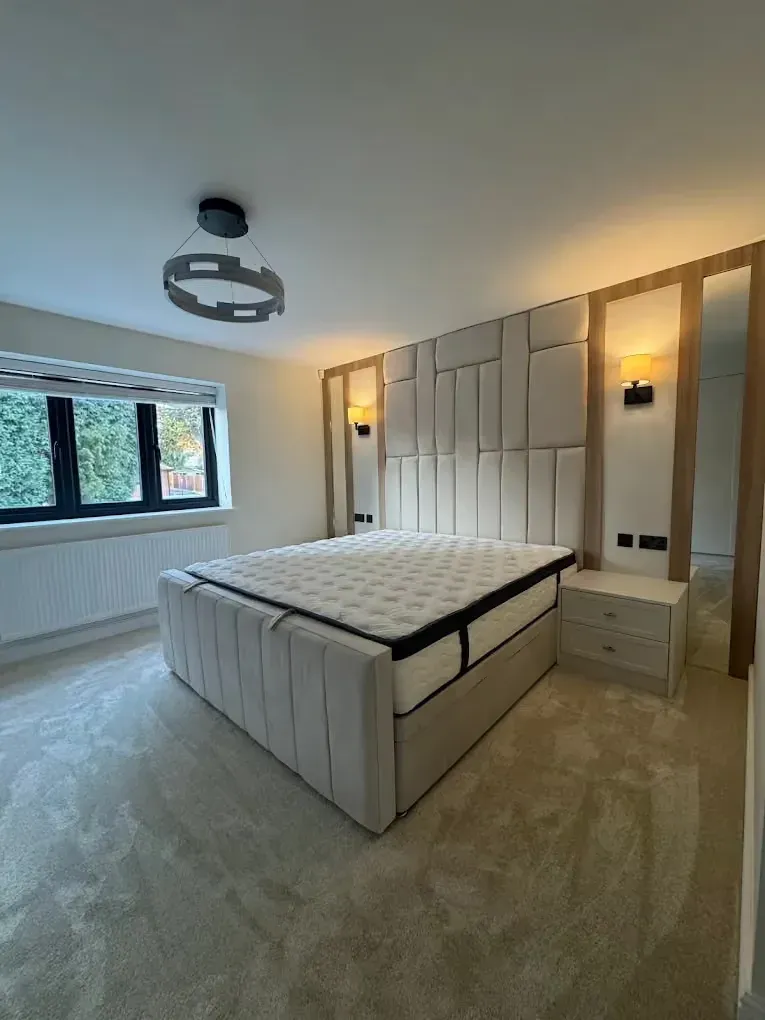Upholstered panelled bed wall with oak detailing and wall lights, real installation