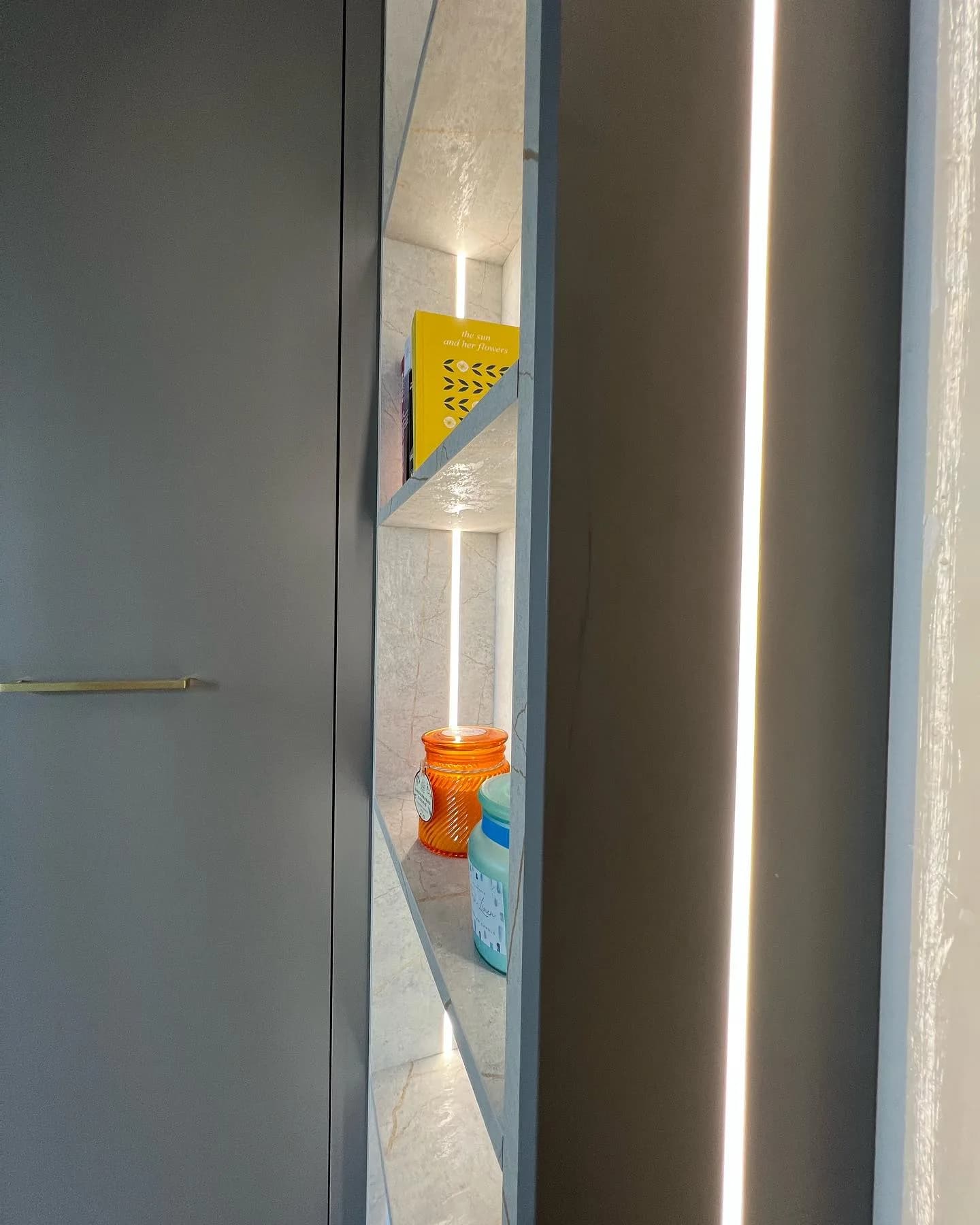 LED-lit display niche cut into grey fitted wardrobes