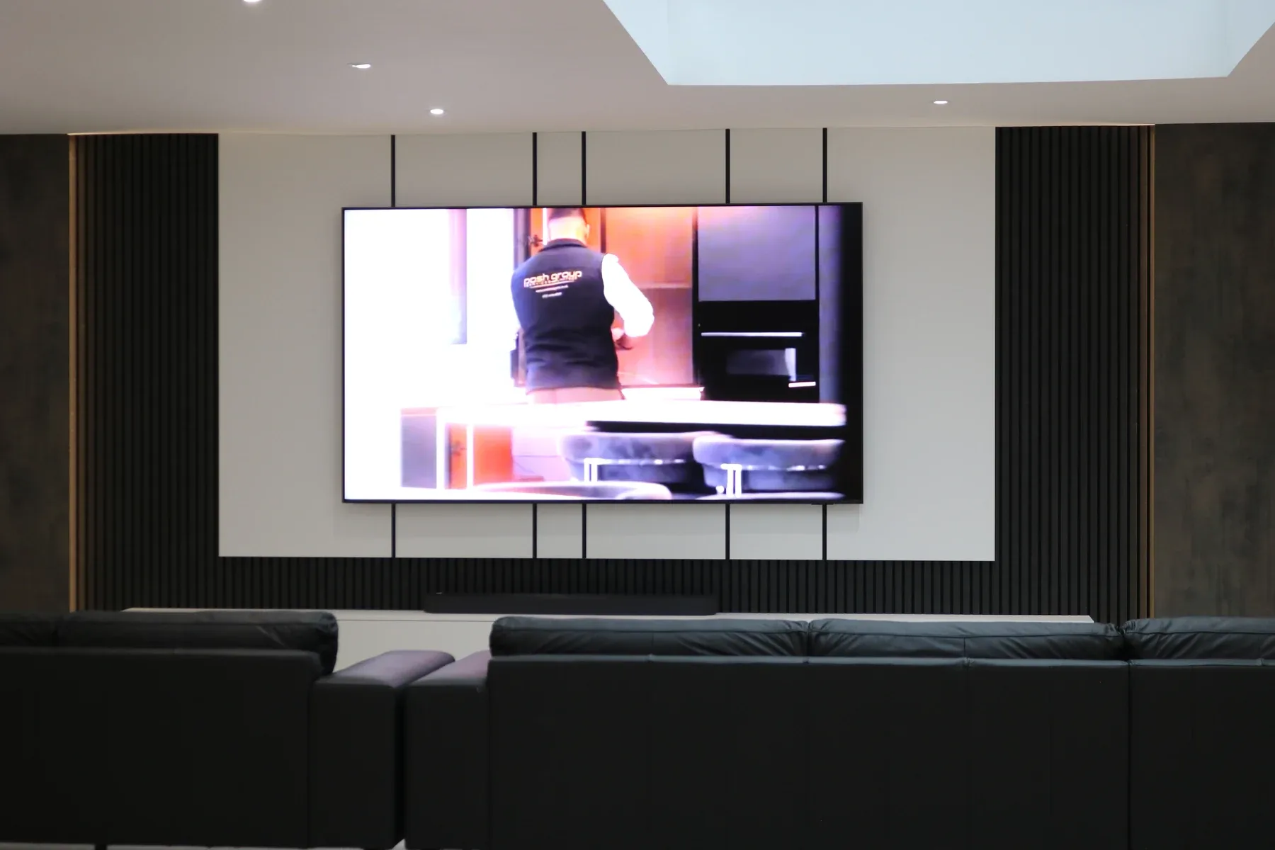 Dark fluted bespoke media wall with recessed television, real installation