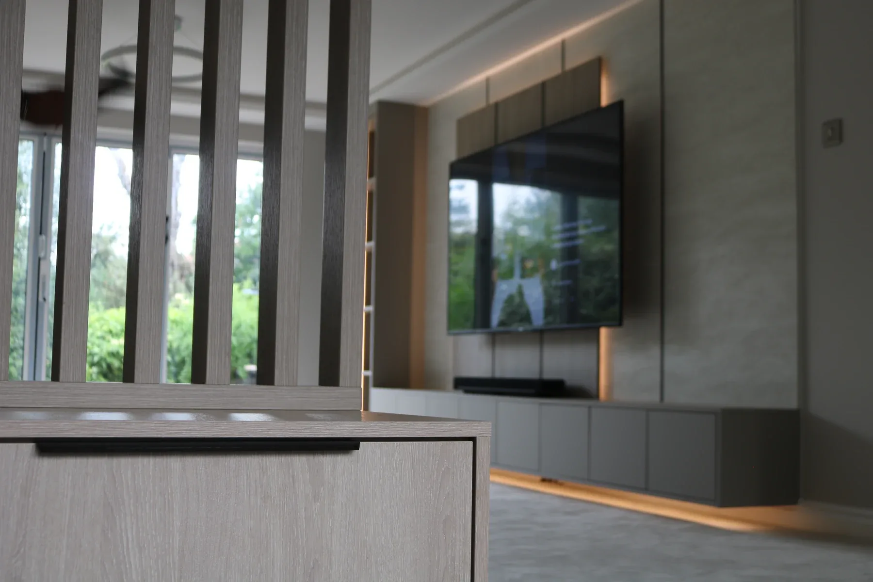 Slatted timber divider with the media wall behind, real installation